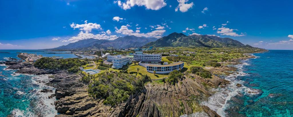 屋久岛THE HOTEL YAKUSHIMA ocean & forest的岩石海岸上的度假村的空中景观