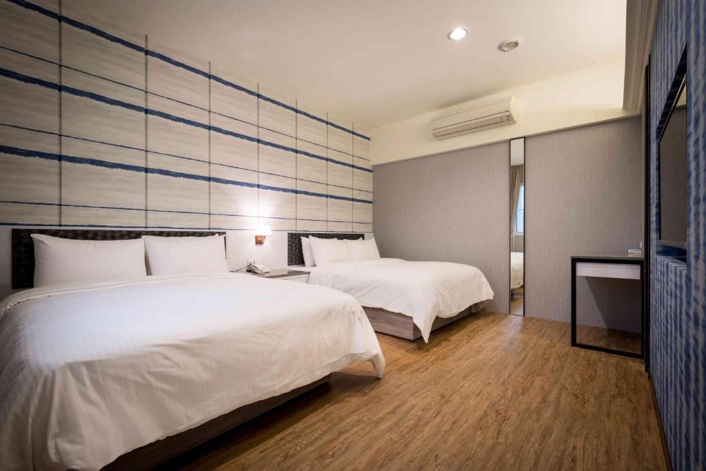 梧栖爱力根汽车旅馆的酒店客房,配有两张带白色床单的床