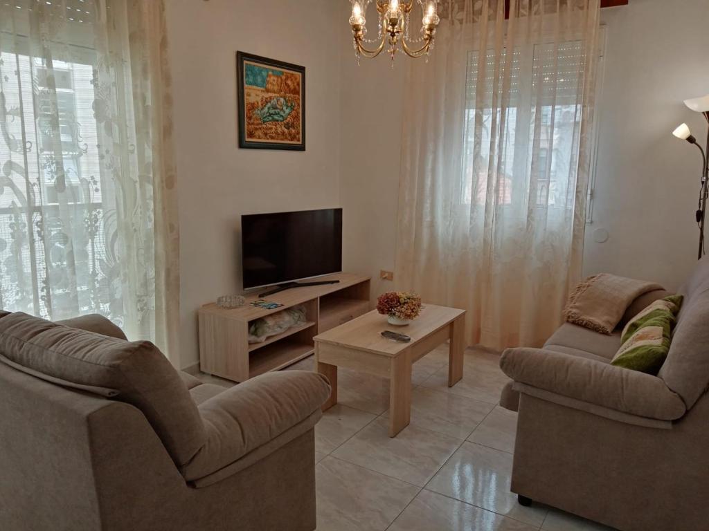 格罗韦Apartamento A Canteira的客厅配有2把椅子和平面电视