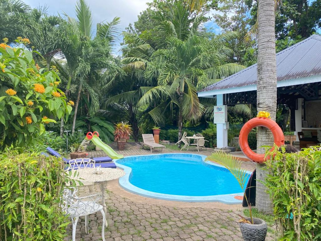 拉迪格岛帕尔马小屋酒店的一座房子旁边的游泳池,带滑梯