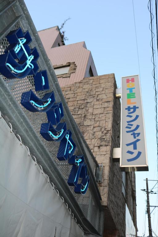宫崎Hotel Sunshine的建筑物一侧的蓝色鞋