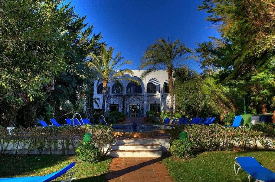 塔里法Hurricane Beach Hotel的一座带蓝色草坪椅子和游泳池的房子