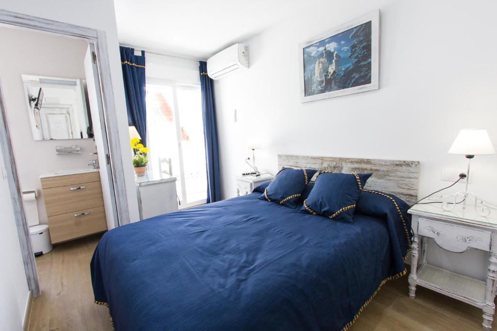 马贝拉Hostal La Estrella的一间卧室配有蓝色的床和镜子