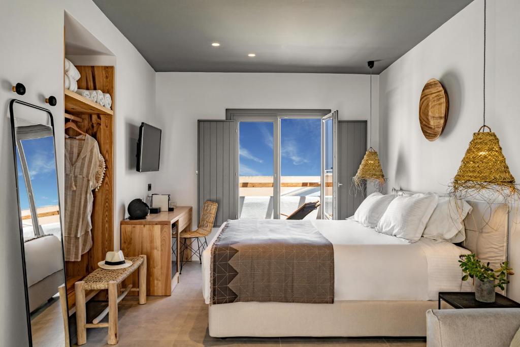 费拉Lemon Suites Santorini的一间带大床的卧室和一个阳台