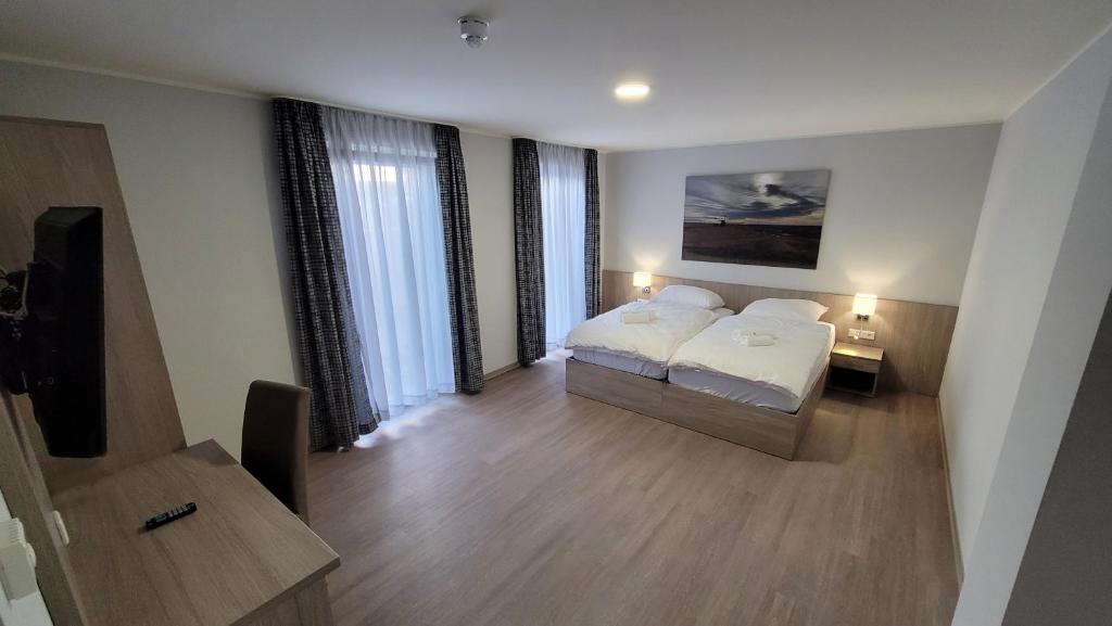JüchenLandgasthof Kelzenberg的一间卧室配有两张床和电视。