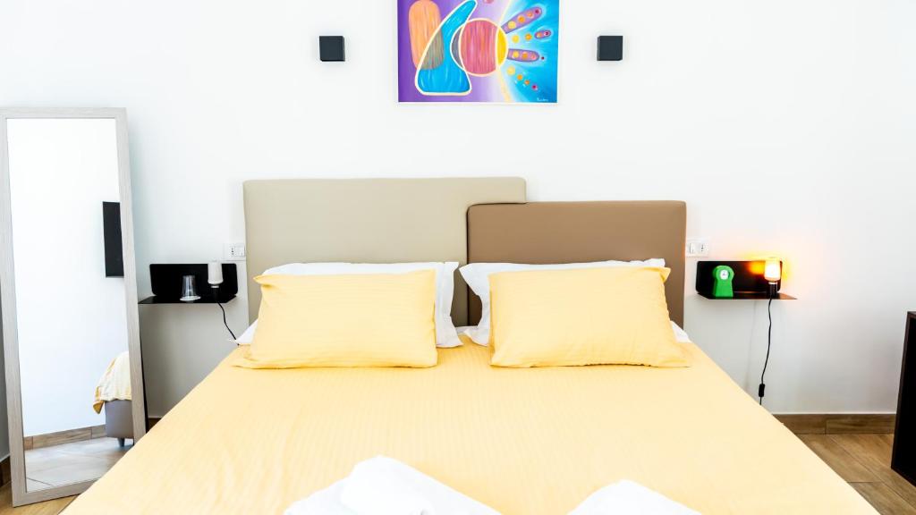 卡塞塔Zeta Rooms的一间卧室配有一张带两个黄色枕头的床