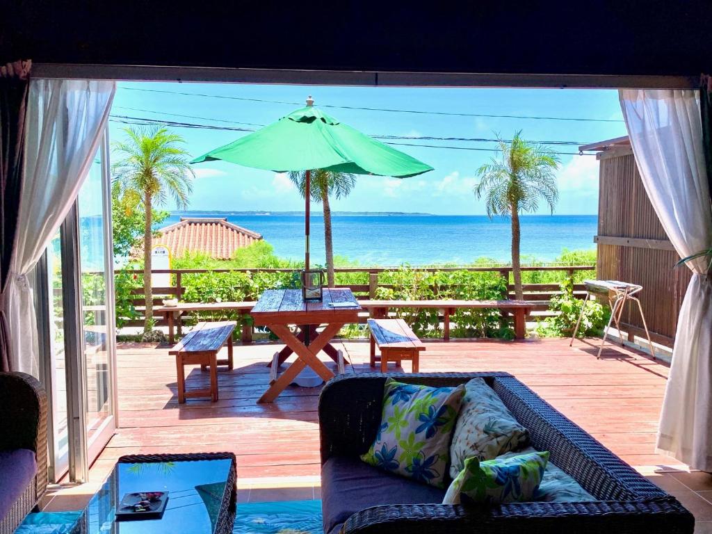 石垣岛石垣岛露台套房度假屋的带沙发和遮阳伞的客厅