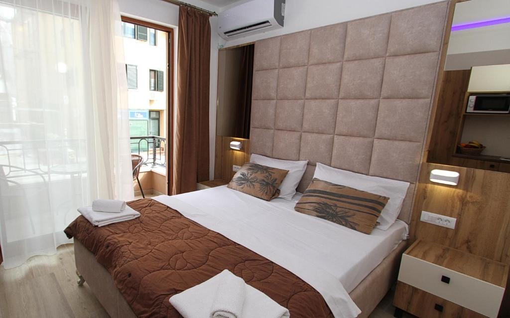 布德瓦Baron的一间卧室设有一张大床和一个大窗户