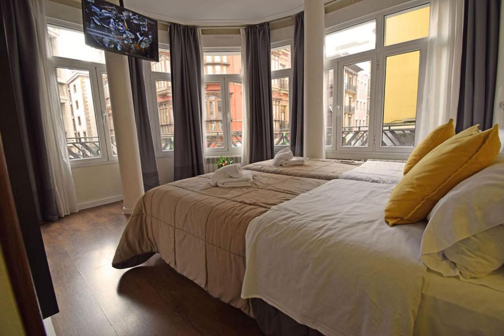 希洪Hostel Gijón Centro的一间卧室配有一张带窗户的大床和电视。