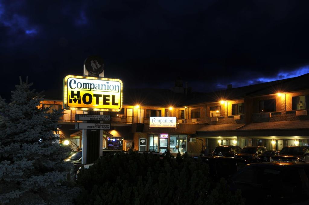 赫斯特Companion Hotel Motel的夜间在大楼前的汽车旅馆标志