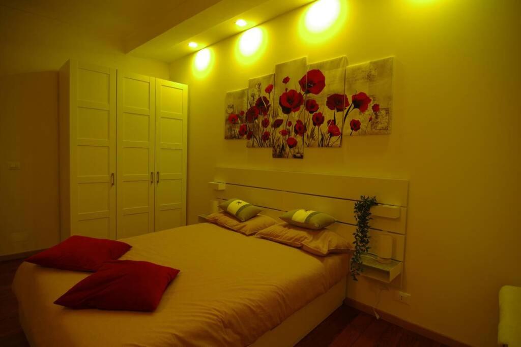 伊夫雷亚Dolce Eporedia intero alloggio nel centro storico的一间卧室配有红色和黄色枕头的床