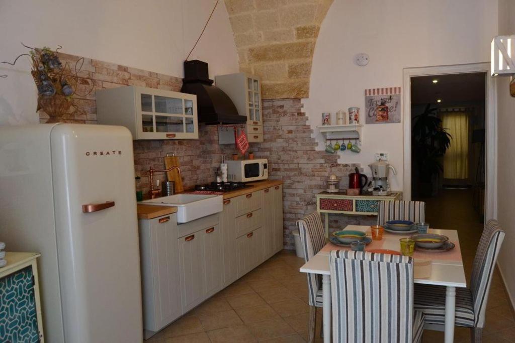 布林迪西Casa Melania的厨房配有桌子和白色冰箱。