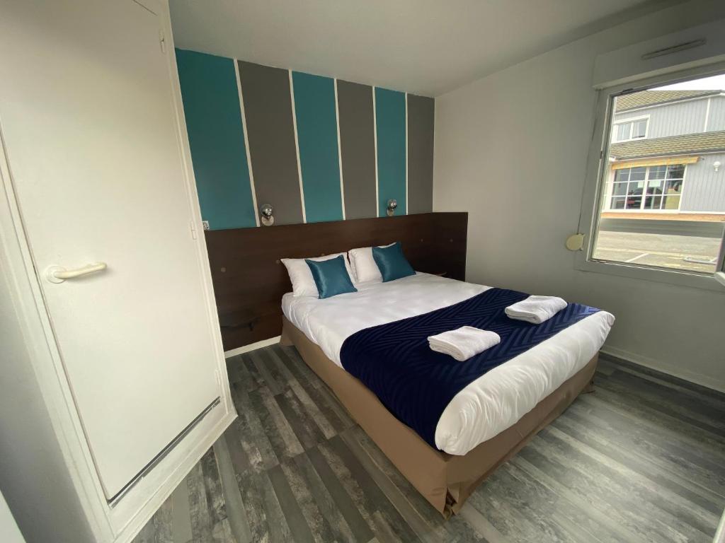 Parçay-Meslay北图尔法斯特酒店的一间卧室配有一张床,上面有两条毛巾