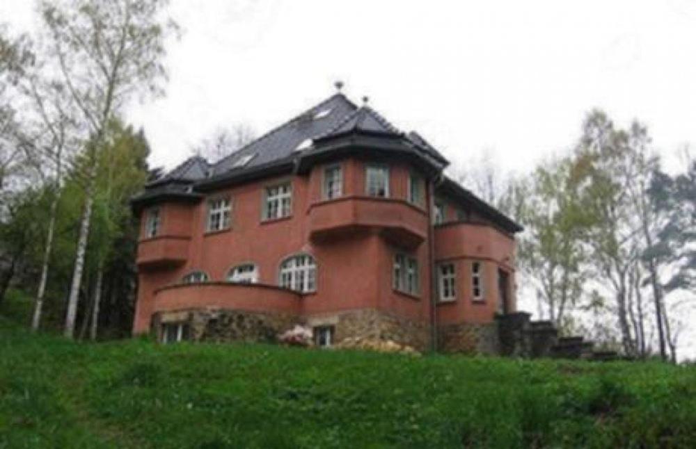 波兰尼卡-兹德鲁伊Baltic Home的一座大红砖建筑,位于草地山上