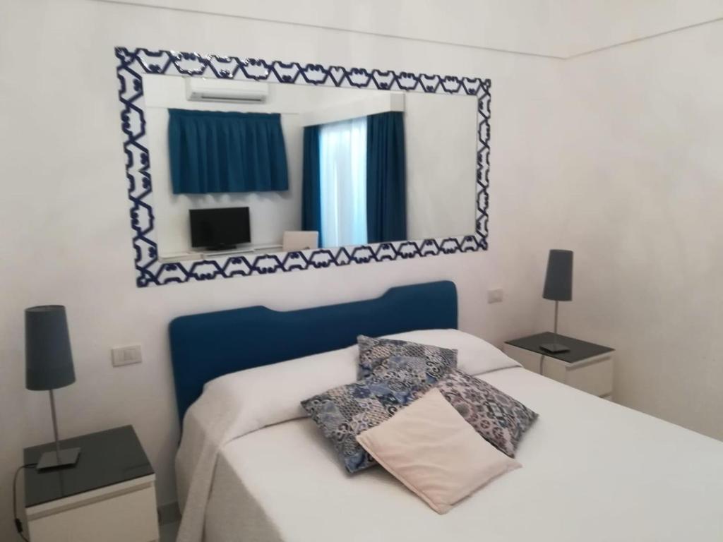 卡普里Casa Vacanza Al Centro di Capri的卧室配有一张壁挂镜子的床