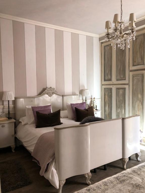 Viggiù老杨树公寓的卧室配有一张带紫色枕头的大型白色床。