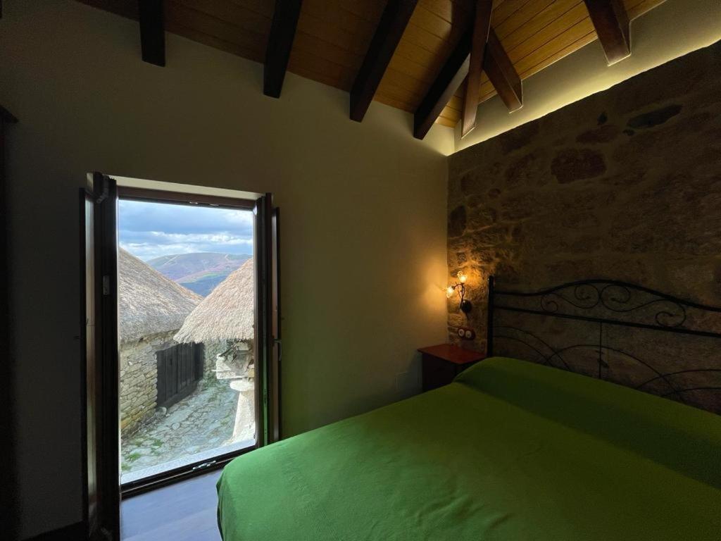 PiornedoCasa Casoa的一间卧室设有一张绿色的床和一个窗户。