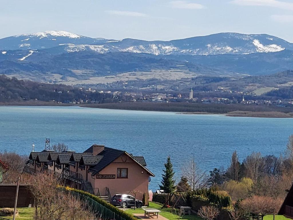 耶维克Ośrodek Wypoczynkowy Nad Jeziorem的享有湖泊和山脉美景的度假屋