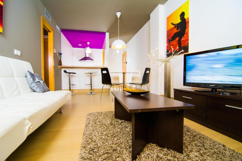 阿尔么丽亚阿尔梅利亚16:9套房公寓酒店的客厅配有白色沙发和平面电视。