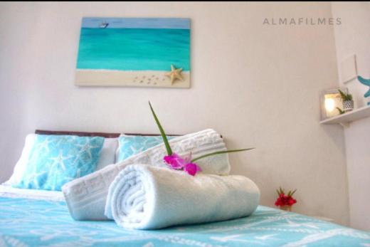 阿布拉奥Suites Casa Azul-Vila do Abraão- conforto, limpeza, ótima localização的一间卧室配有一张床,床上有毛巾