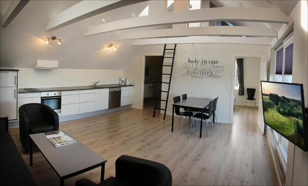 StenildVolstrup Apartments的配有桌椅和厨房的房间