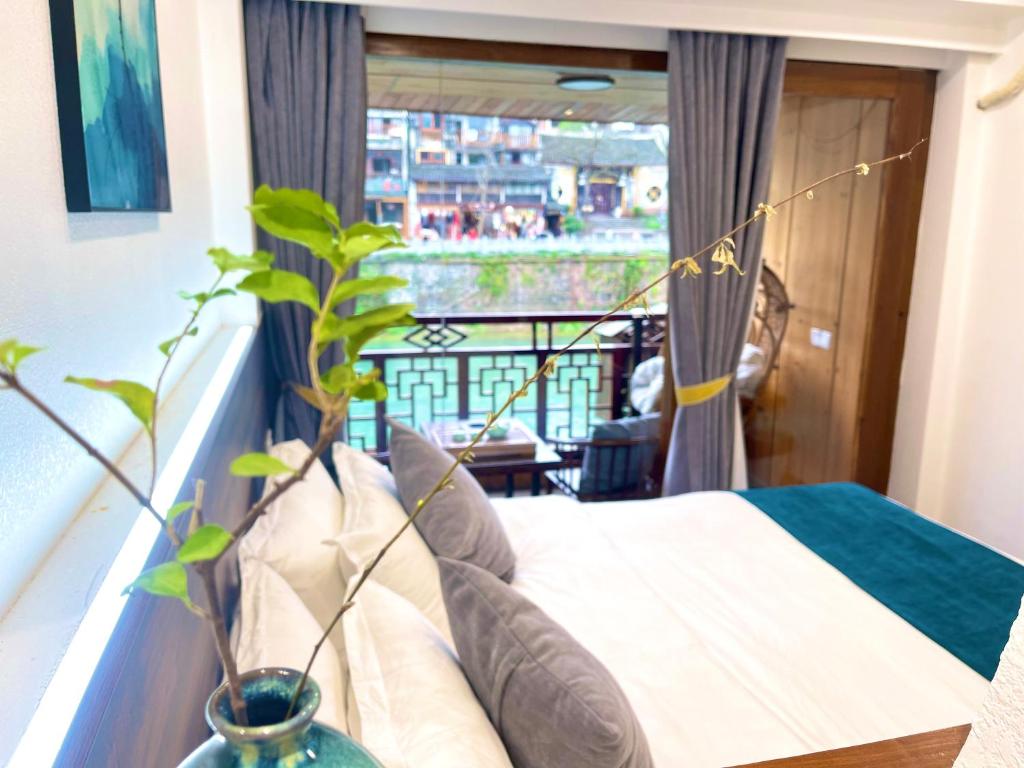 凤凰边城杏子客栈 的一间卧室设有一张床和一个阳台