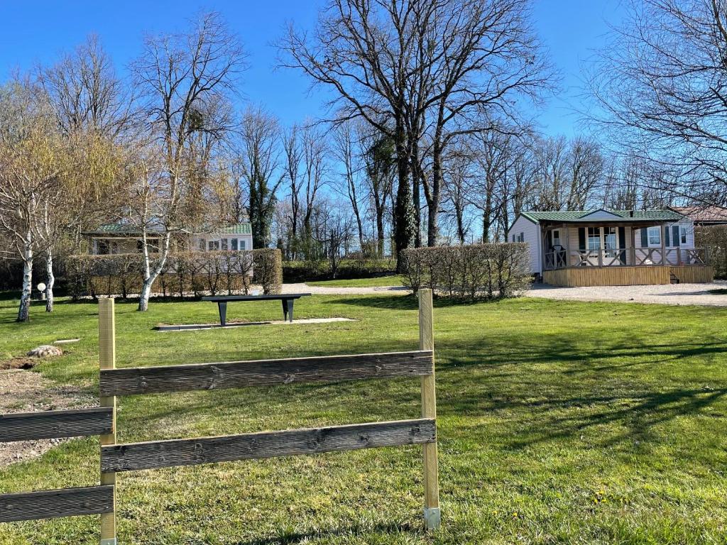 MarignyJura mobile home的一座带木栅栏和房屋的公园