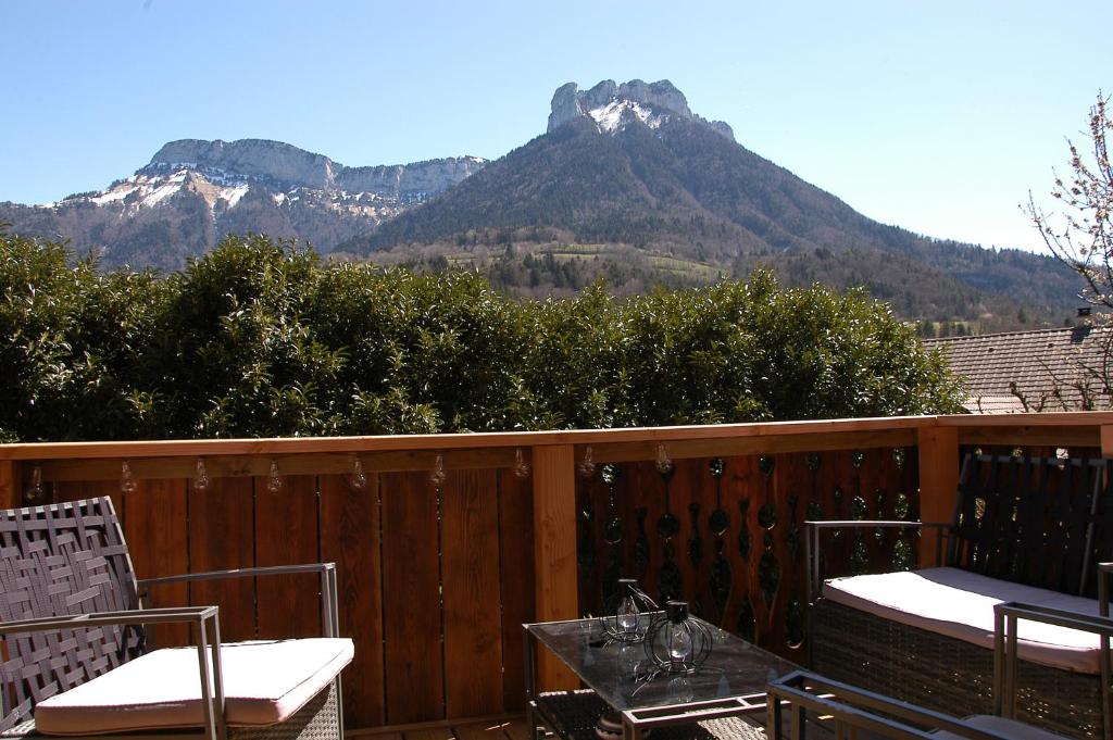 阿莱克斯Le P'tit Chalet de la Fressine的阳台配有桌椅,享有山景。