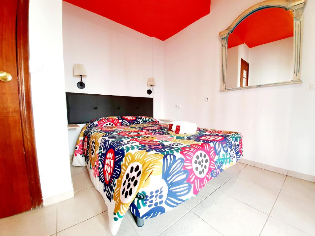 科尔多瓦Arc House Ribera Only Adults的一间卧室配有一张带五颜六色棉被的床