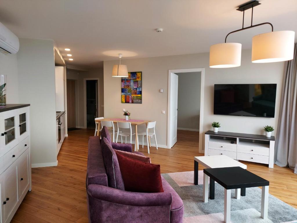 斯文托伊Irklo apartamentai su vaizdu į jūrą的客厅配有紫色沙发和桌子
