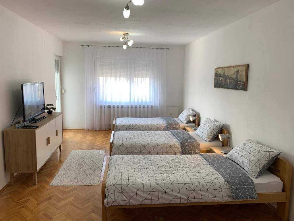 Dubrave GornjeApartmani Nedim的一间卧室配有两张床和电视。