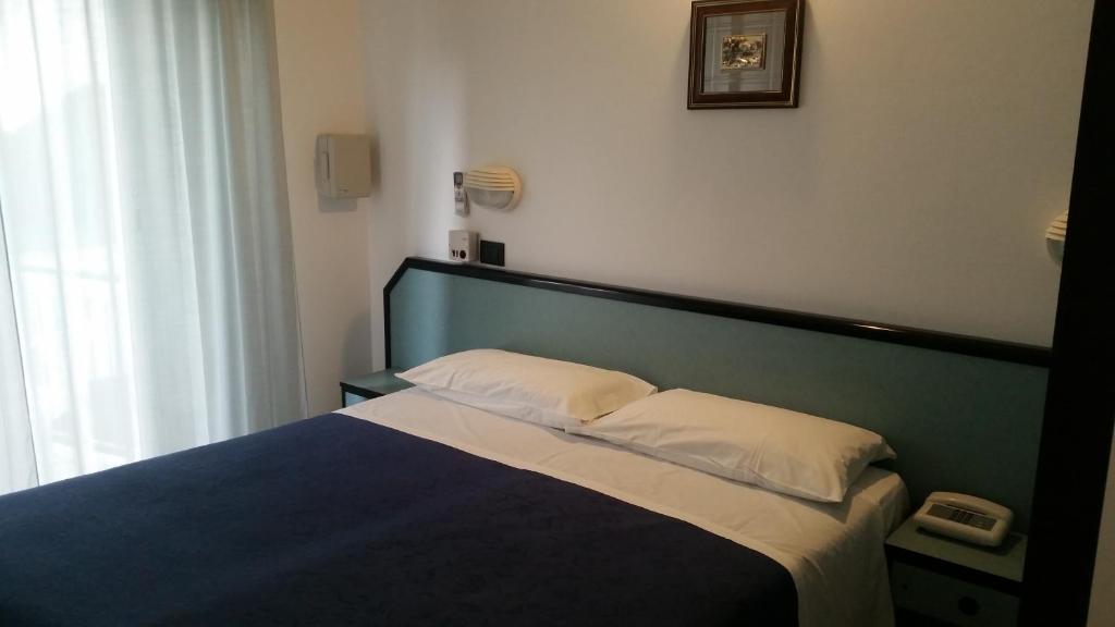 里乔内卡拉维拉酒店的一间卧室配有一张蓝色床头板的床