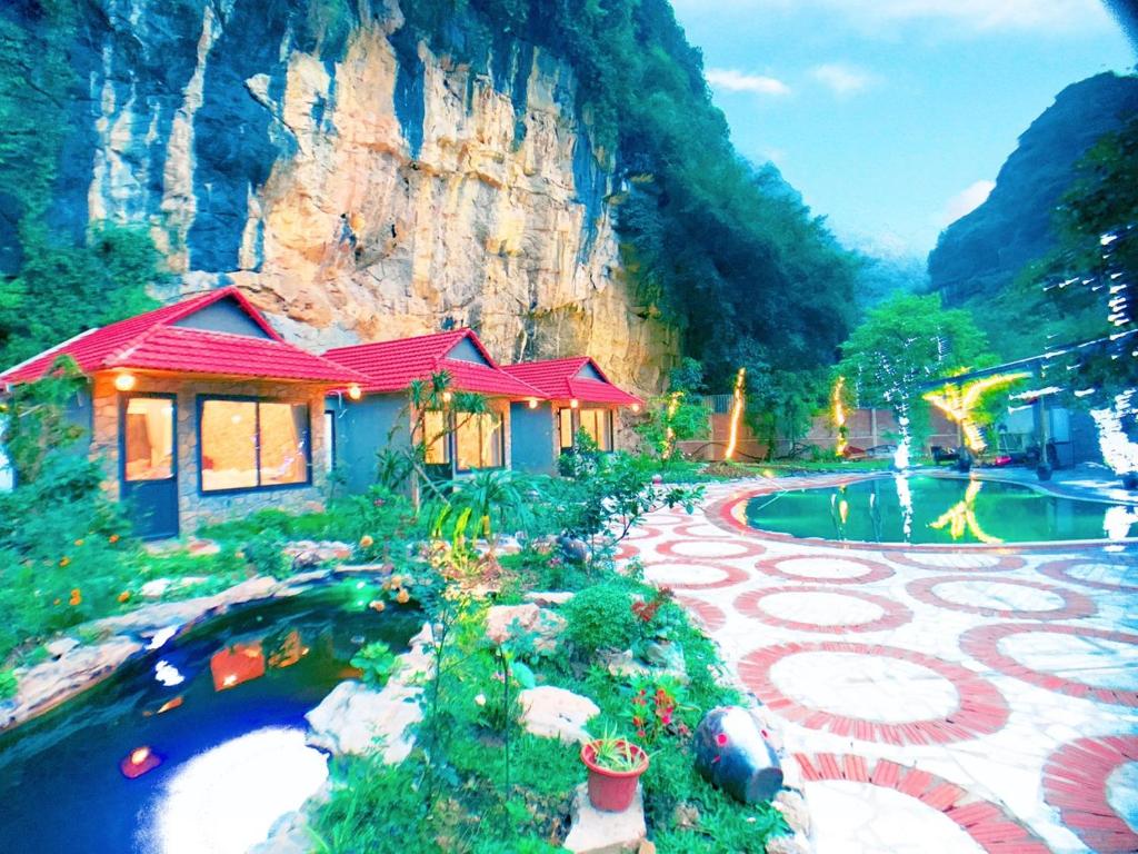 宁平Trang An Peaceful Homestay的一座带池塘的房子和一座建筑的画