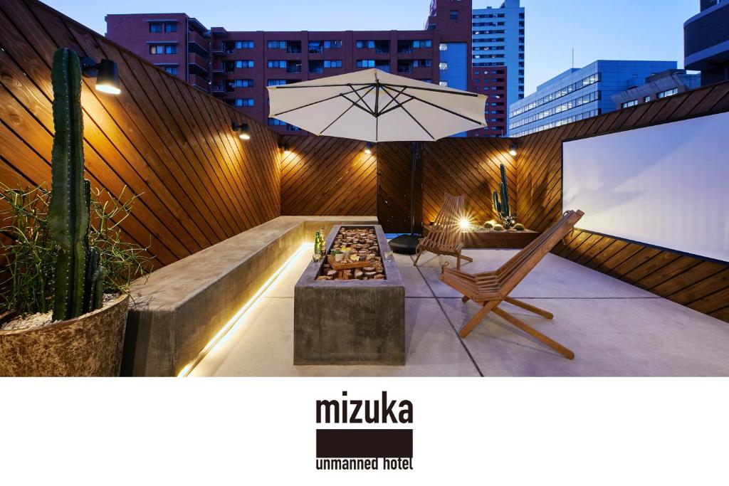 福冈mizuka Daimyo 7 - unmanned hotel -的一个带桌子和遮阳伞的庭院