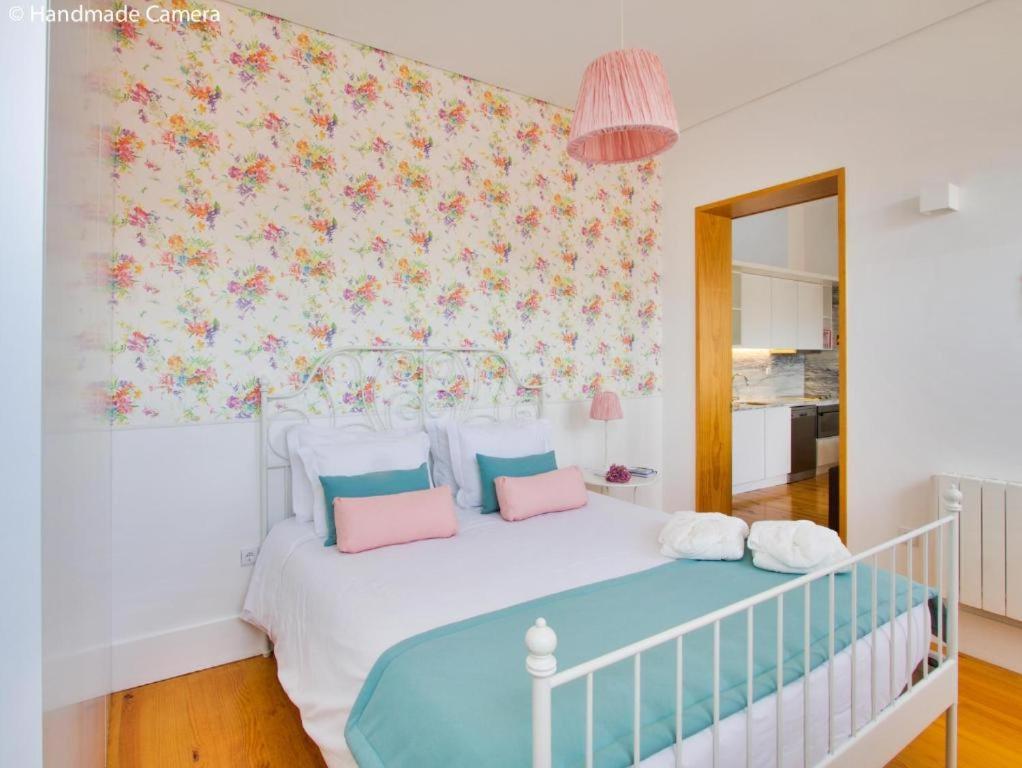 波尔图Inside Porto Apartments - Flores的卧室配有白色床和粉红色及蓝色枕头