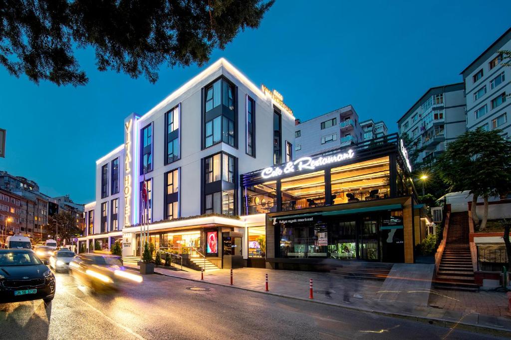 伊斯坦布尔Vital Hotel Fulya Istanbul Sisli的城市街道上的一座建筑,汽车驶过