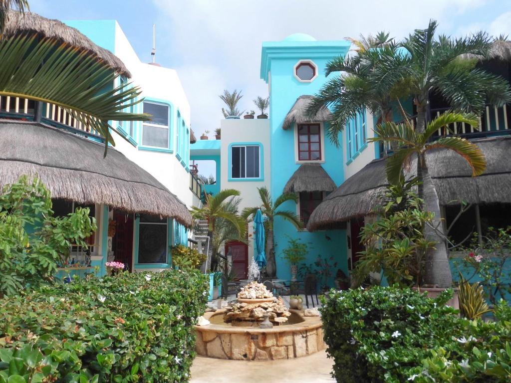 艾库玛尔加托斯之家酒店的蓝色的建筑,前面有一个喷泉