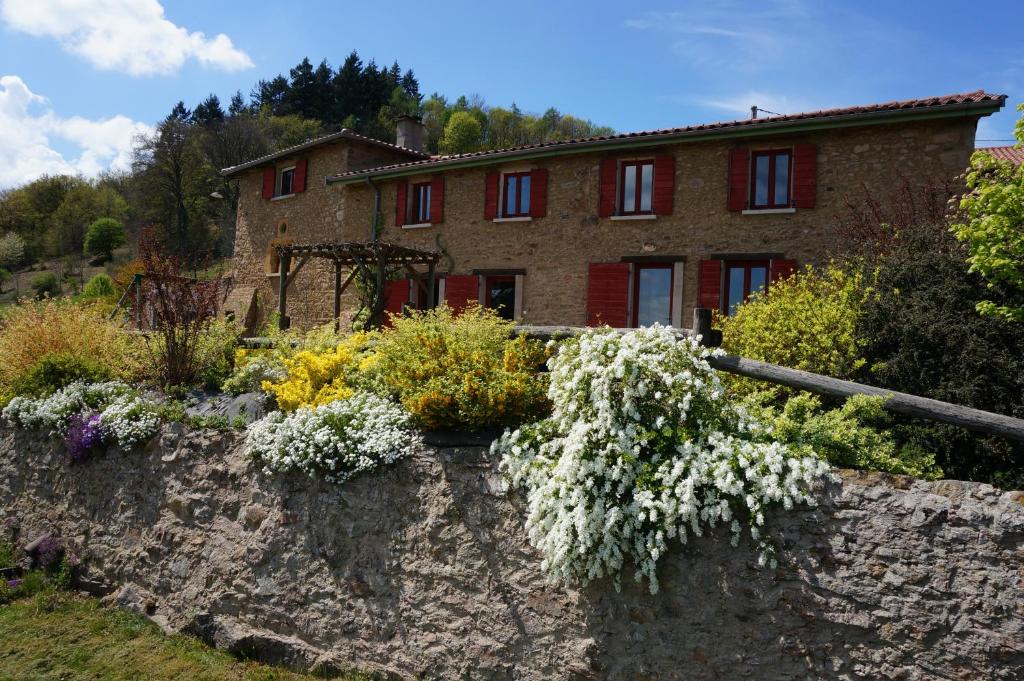 MontromantAuberge du Thiollet的房子前方有花的石墙