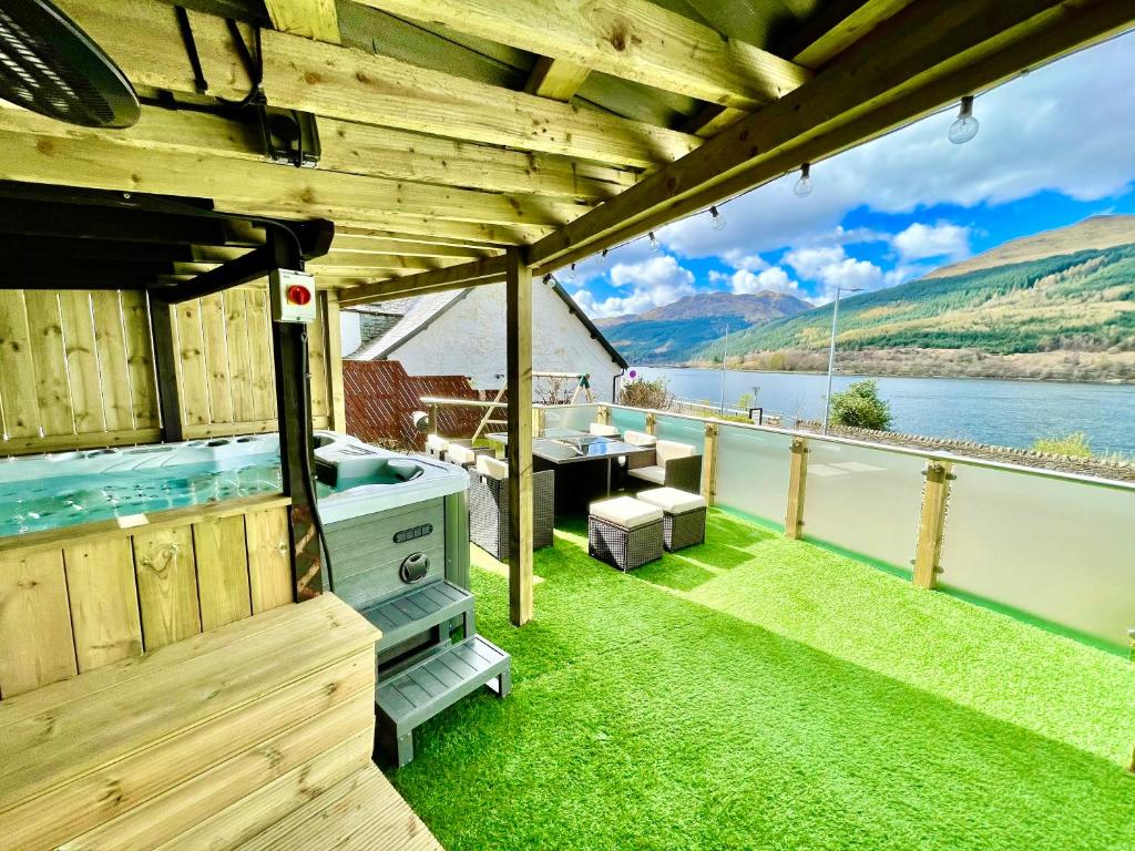 阿罗柴尔Amazing Alps and Loch views - HOT TUB and pet friendly的船上甲板上的热水浴池