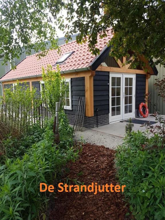奥德多普Vakantie Ouddorp的一个小蓝色房子,设有门廊和门