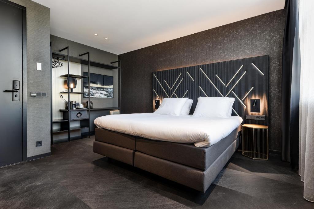 鹿特丹Le Marin Boutique Hotel的一间卧室设有一张大床和黑色墙壁