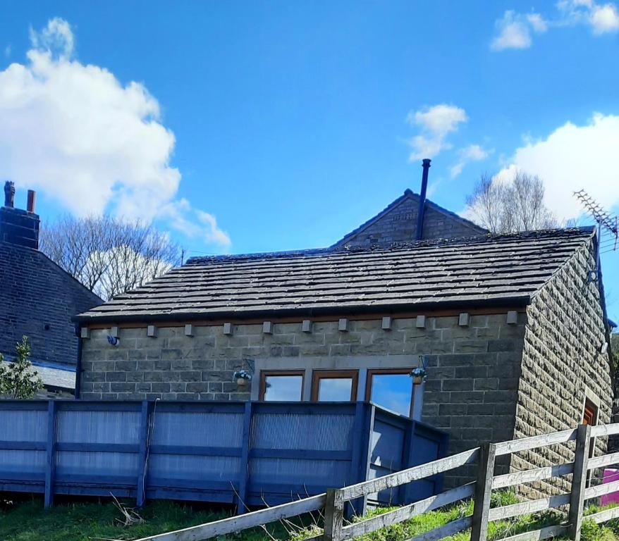 MarsdenBank Bottom Cottage的前面有栅栏的砖房
