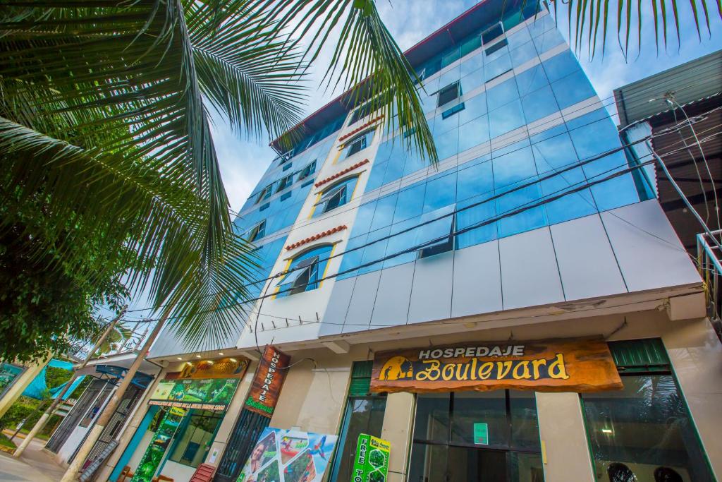 马尔多纳多港Hotel Boulevard的前面有棕榈树的建筑