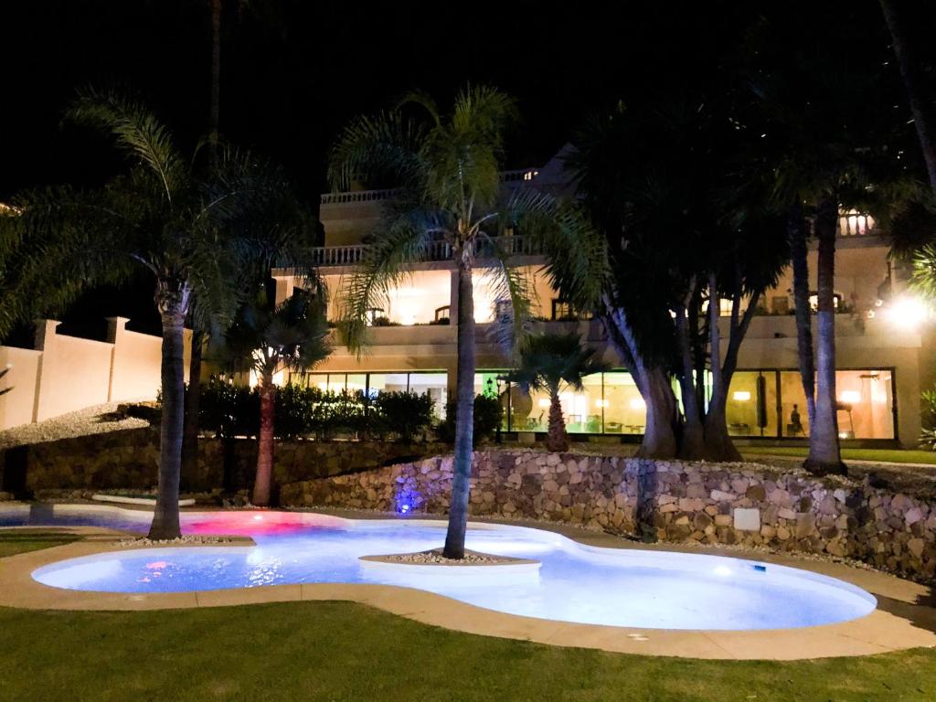 EsteponaHuge Golf and Spa Mansion 8 min from Puerto Banus的一座楼前棕榈树的大型游泳池
