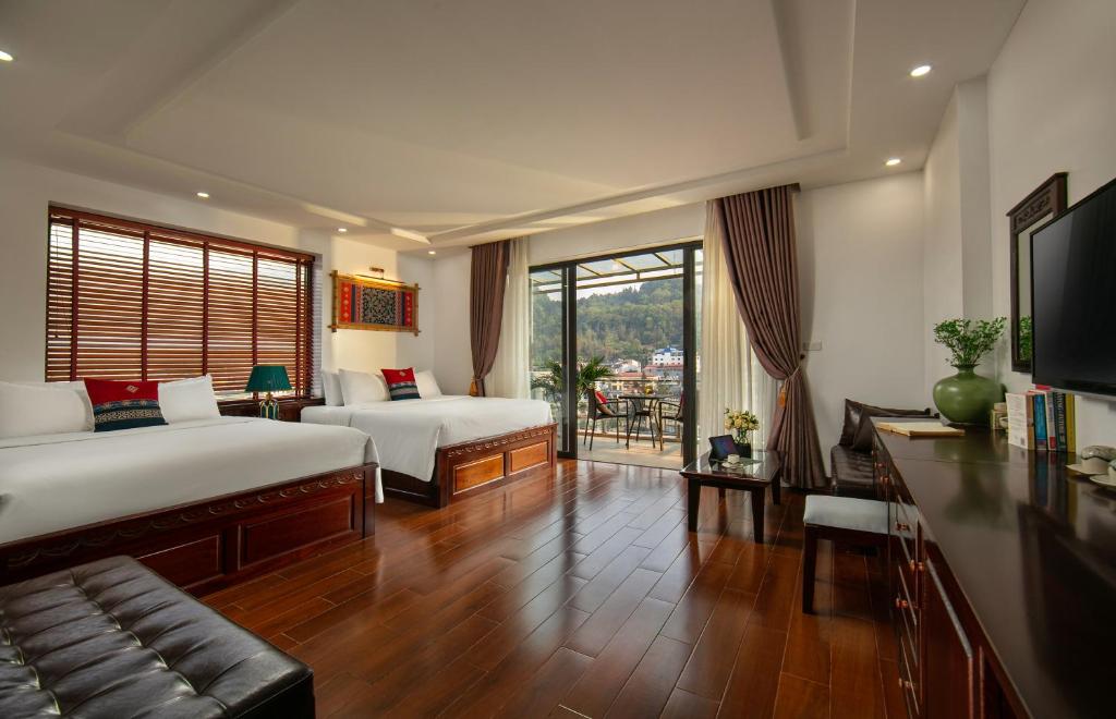 萨帕Sapa Mountain Queen House的酒店客房设有两张床和电视。