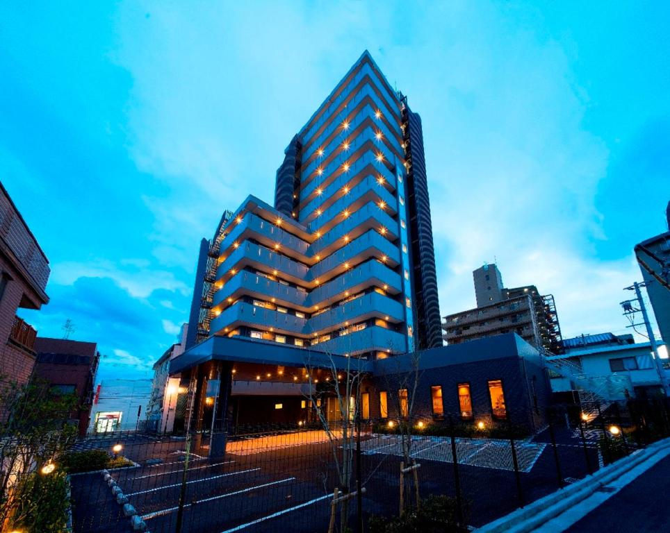 高石市HOTEL ROUTE-INN Osaka Takaishi Hagoromo Ekimae的夜晚在城市的高楼