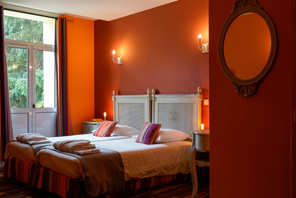 蒙蒂尼布勒托讷奥柏格杜马奈酒店的一间卧室设有橙色的墙壁和一张带镜子的床