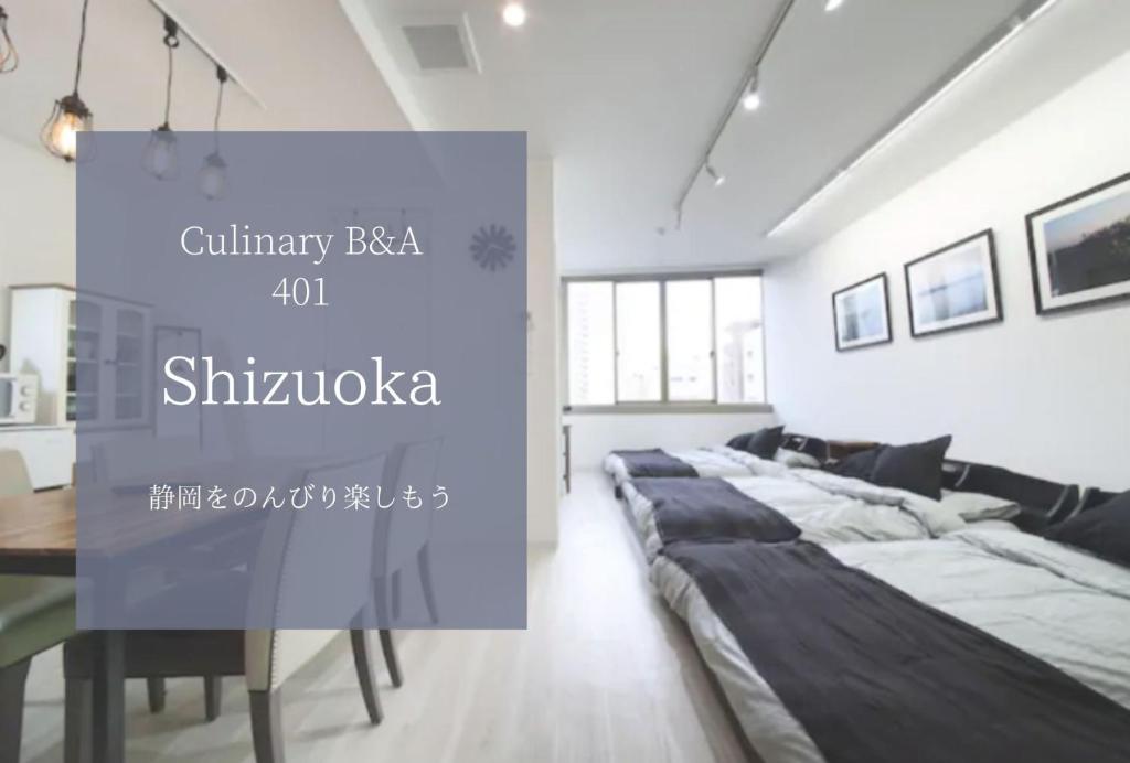 滨松Culinary Bed&Art 401的一间卧室配有一张大床和一张桌子