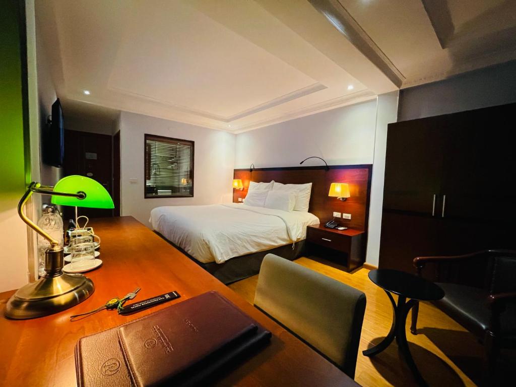 宁平宁平温哥华酒店的一间卧室配有一张床和一张带笔记本电脑的书桌