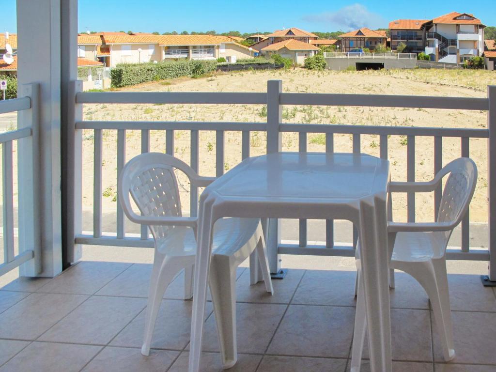 比斯卡罗斯海滩Apartment Résidence Belle Dune - BPL331 by Interhome的海滩阳台的一张桌子和两把椅子